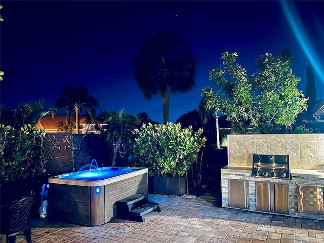 4907 Kilty Ct E, Bradenton, FL 34203 - patio at night featuring a hot tub, area for grilling, and a patio