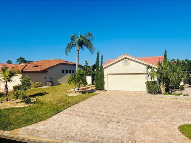 4907 Kilty Ct E, Bradenton, FL 34203 - mediterranean / spanish-style house featuring decorative driveway, stucco siding, a front lawn, a tile roof, and an attached garage