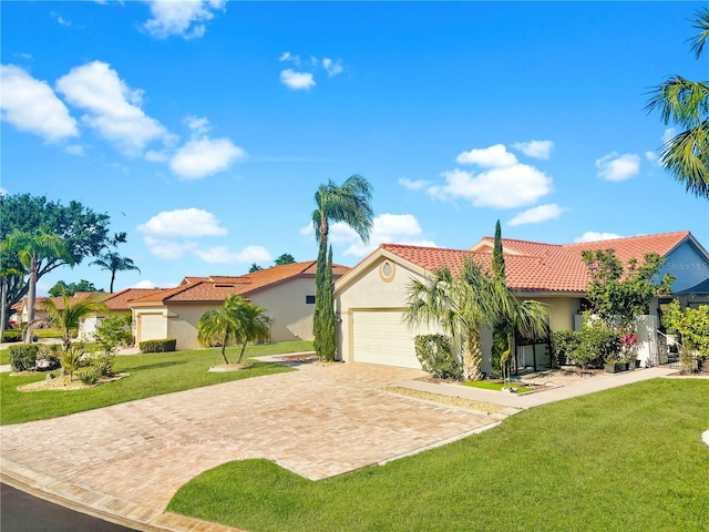4907 Kilty Ct E, Bradenton, FL 34203 - mediterranean / spanish-style home featuring stucco siding, decorative driveway, a tile roof, a garage, and a front yard