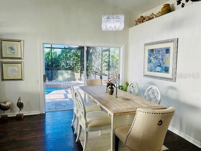 4907 Kilty Ct E, Bradenton, FL 34203 - dining space featuring plenty of natural light, a chandelier, wood finished floors, and high vaulted ceiling