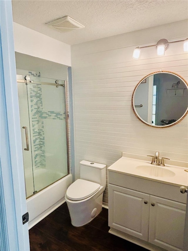 4907 Kilty Ct E, Bradenton, FL 34203 - full bathroom featuring wood finished floors, vanity, a textured ceiling, and bath / shower combo with glass door