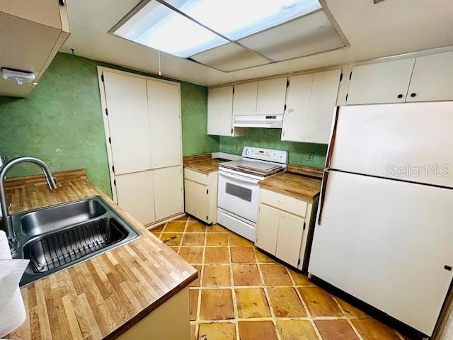 2607 29th Ave W, Bradenton, FL 34205 - kitchen with white appliances, under cabinet range hood, a sink, and wood counters