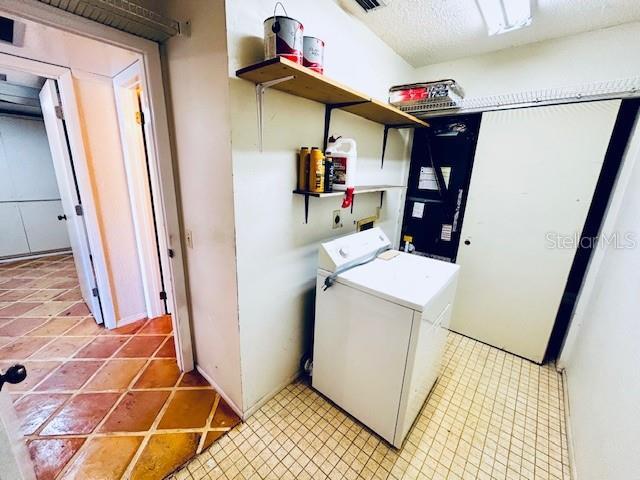 2607 29th Ave W, Bradenton, FL 34205 - laundry area with washer and dryer and light tile patterned flooring