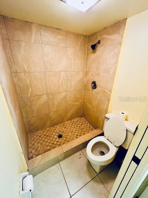 2607 29th Ave W, Bradenton, FL 34205 - bathroom with a tile shower, toilet, and tile patterned flooring
