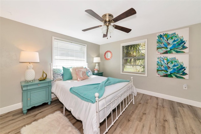 5948 Mirror Lake Rd, Sarasota, FL 34238 - bedroom with wood finished floors, multiple windows, and a ceiling fan