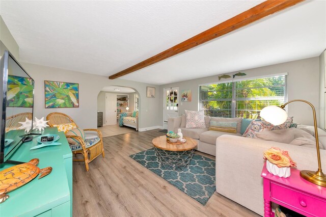 5948 Mirror Lake Rd, Sarasota, FL 34238 - living room with arched walkways, beam ceiling, and wood finished floors