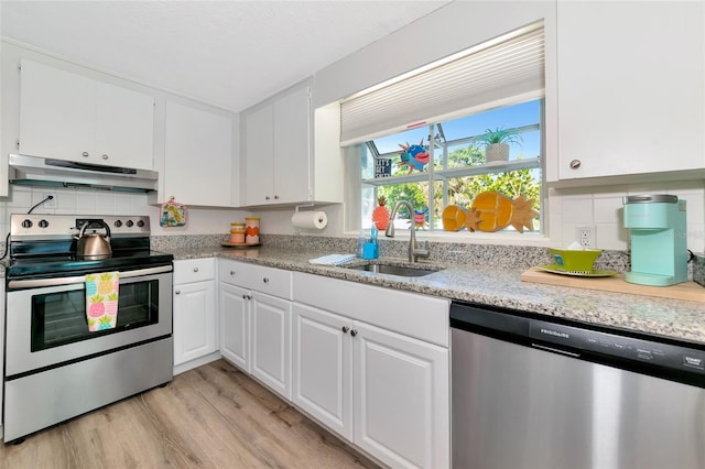 5948 Mirror Lake Rd, Sarasota, FL 34238 - kitchen featuring stainless steel appliances, under cabinet range hood, white cabinetry, tasteful backsplash, and light wood-style flooring