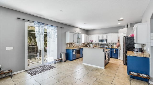 8804 Founders Cir, Palmetto, FL 34221 - kitchen with stainless steel appliances, blue cabinets, backsplash, white cabinetry, and a kitchen island