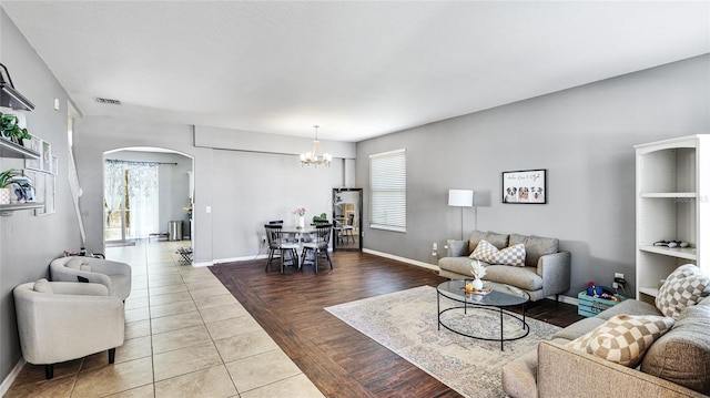 8804 Founders Cir, Palmetto, FL 34221 - living room with arched walkways, a chandelier, and tile patterned floors