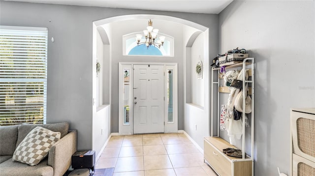 8804 Founders Cir, Palmetto, FL 34221 - foyer featuring a chandelier, plenty of natural light, light tile patterned flooring, and arched walkways
