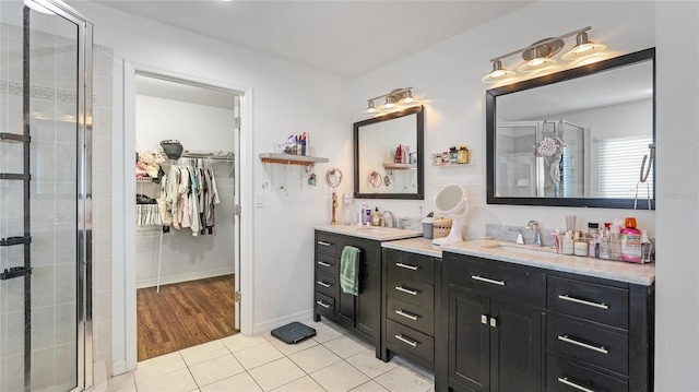 8804 Founders Cir, Palmetto, FL 34221 - full bathroom featuring double vanity, a spacious closet, a stall shower, and tile patterned floors