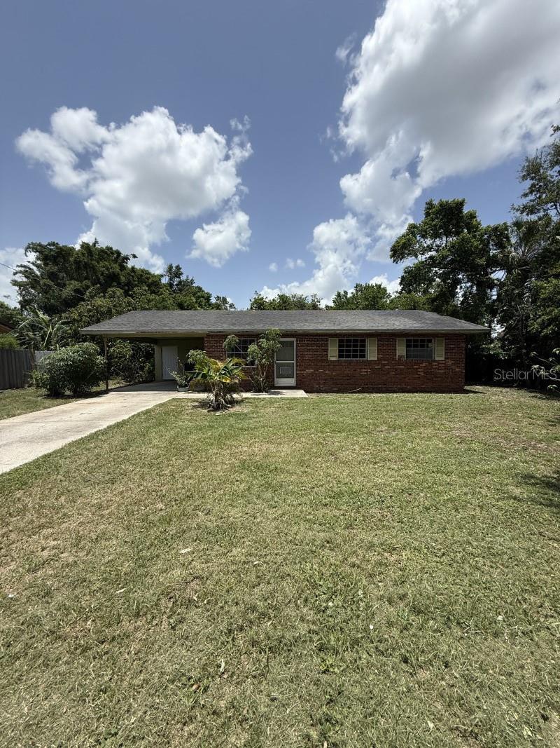 1516 Ave D NE, Winter Haven, FL 33881 - ranch-style home featuring concrete driveway, a carport, a front lawn, and brick siding
