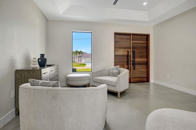 289 Long Meadow Ln, Rotonda West, FL 33947 - living area with a raised ceiling, baseboards, and concrete floors