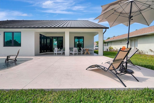 289 Long Meadow Ln, Rotonda West, FL 33947 - rear view of property with stucco siding, a standing seam roof, a patio area, and metal roof