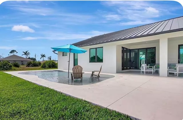 289 Long Meadow Ln, Rotonda West, FL 33947 - back of property featuring a standing seam roof, a patio, metal roof, a lawn, and stucco siding