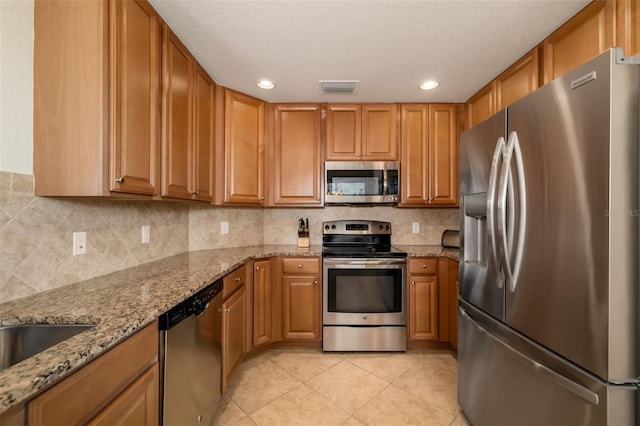 6923 Grand Estuary Trl Unit 101, Bradenton, FL 34212 - kitchen featuring appliances with stainless steel finishes, light stone countertops, light tile patterned floors, tasteful backsplash, and recessed lighting