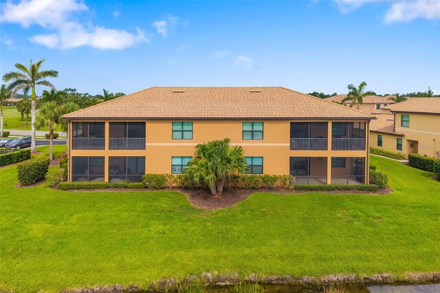 6923 Grand Estuary Trl Unit 101, Bradenton, FL 34212 - back of house featuring stucco siding, a yard, and a sunroom