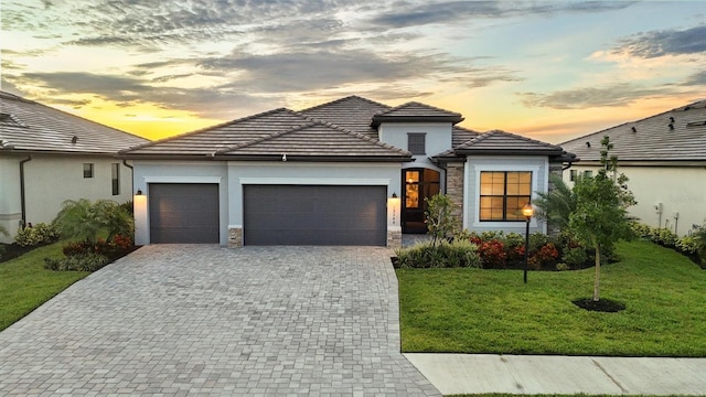 15344 Serene Shores Loop, Lakewood Ranch, FL 34211 - view of front of home with an attached garage, decorative driveway, a front lawn, stucco siding, and a tile roof