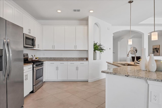15344 Serene Shores Loop, Lakewood Ranch, FL 34211 - kitchen featuring appliances with stainless steel finishes, white cabinets, light tile patterned floors, pendant lighting, and light stone countertops
