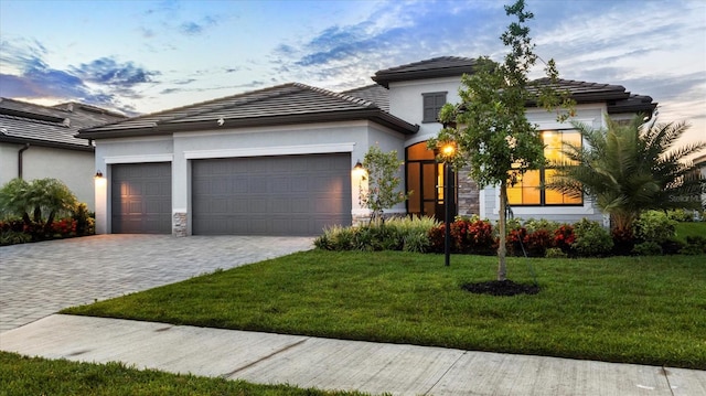 15344 Serene Shores Loop, Lakewood Ranch, FL 34211 - view of front of property with an attached garage, decorative driveway, a front yard, stone siding, and stucco siding