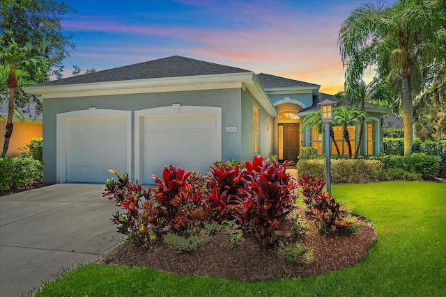 5508 Whitehead St, Bradenton, FL 34203 - ranch-style home with stucco siding, a garage, driveway, a lawn, and a shingled roof
