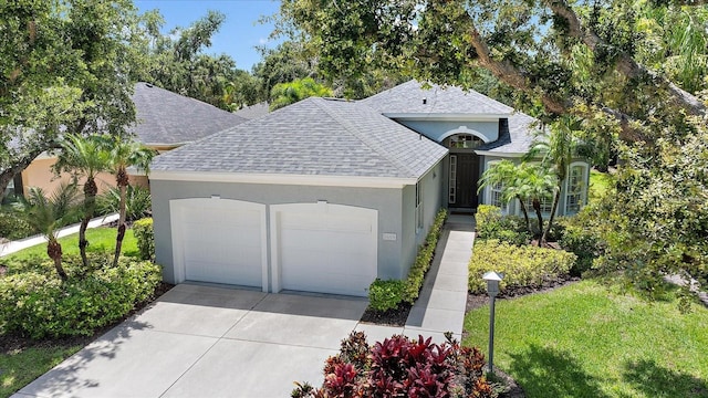 5508 Whitehead St, Bradenton, FL 34203 - view of front of home with roof with shingles, stucco siding, a garage, driveway, and a front yard