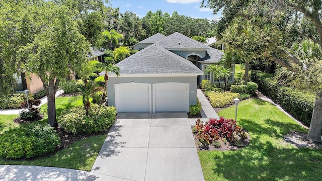 5508 Whitehead St, Bradenton, FL 34203 - view of front facade featuring a shingled roof, stucco siding, a front lawn, driveway, and an attached garage
