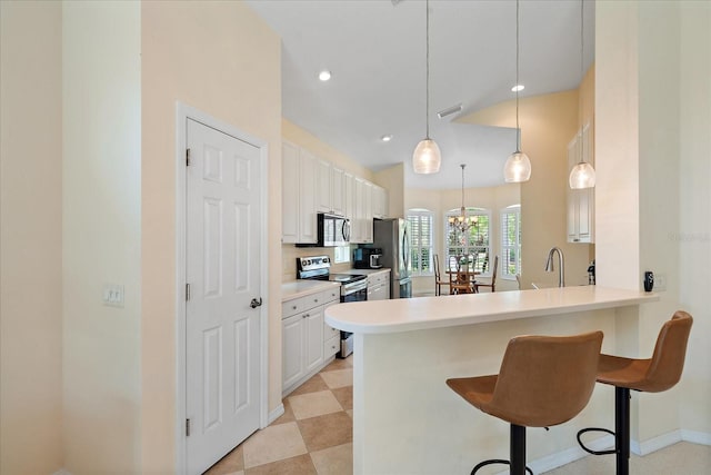 5508 Whitehead St, Bradenton, FL 34203 - kitchen with stainless steel appliances, a breakfast bar area, white cabinets, light countertops, and recessed lighting