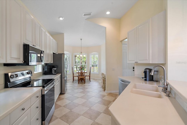 5508 Whitehead St, Bradenton, FL 34203 - kitchen with stainless steel appliances, white cabinets, recessed lighting, decorative light fixtures, and light countertops