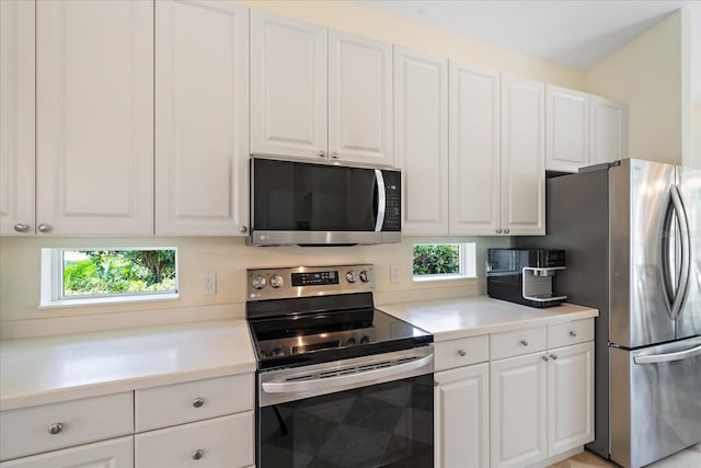 5508 Whitehead St, Bradenton, FL 34203 - kitchen with appliances with stainless steel finishes, plenty of natural light, white cabinets, and light countertops