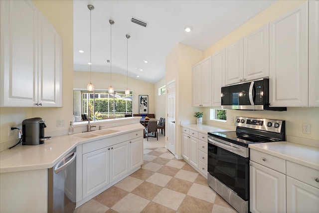 5508 Whitehead St, Bradenton, FL 34203 - kitchen featuring stainless steel appliances, lofted ceiling, white cabinetry, decorative light fixtures, and light countertops