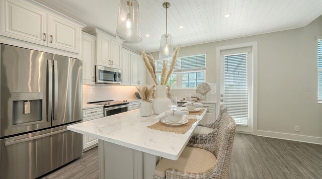 4322 Marina View Way, Cortez, FL 34215 - kitchen with appliances with stainless steel finishes, wood finished floors, wood ceiling, a breakfast bar, and tasteful backsplash