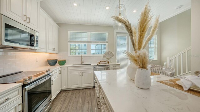 4322 Marina View Way, Cortez, FL 34215 - kitchen featuring stainless steel appliances, a sink, white cabinets, light wood finished floors, and wooden ceiling