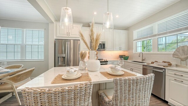 4322 Marina View Way, Cortez, FL 34215 - kitchen featuring appliances with stainless steel finishes, a sink, a kitchen island, decorative backsplash, and white cabinets