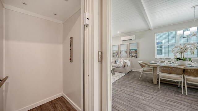 4322 Marina View Way, Cortez, FL 34215 - corridor with elevator, a wall unit AC, wood finished floors, baseboards, and a chandelier