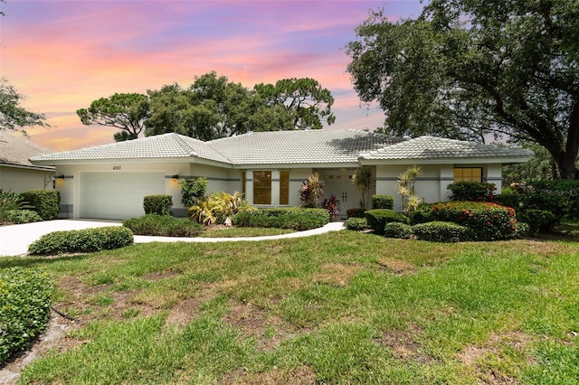 4353 Indian Point Trl, Sarasota, FL 34238 - ranch-style house with an attached garage, a tile roof, a yard, concrete driveway, and stucco siding