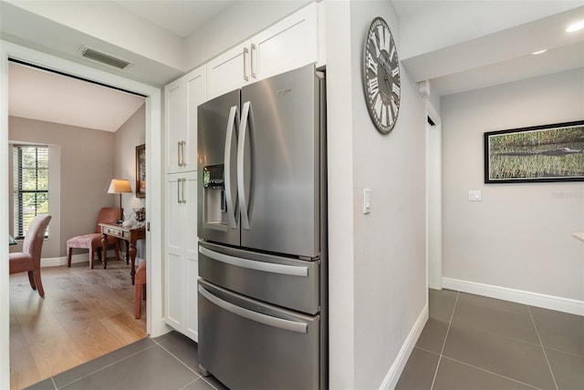 4353 Indian Point Trl, Sarasota, FL 34238 - kitchen featuring stainless steel fridge, white cabinets, and dark tile patterned floors