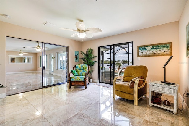 14544 Riverside Dr, Fort Myers, FL 33905 - sitting room featuring light marble finish floors, ceiling fan, and baseboards