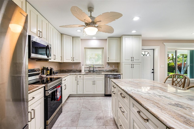 14544 Riverside Dr, Fort Myers, FL 33905 - kitchen with stainless steel appliances, a sink, light stone countertops, recessed lighting, and a ceiling fan