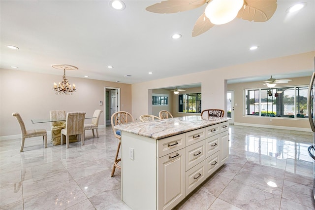 14544 Riverside Dr, Fort Myers, FL 33905 - kitchen featuring light marble finish floors, a breakfast bar area, baseboards, white cabinets, and recessed lighting