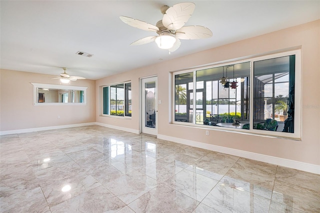 14544 Riverside Dr, Fort Myers, FL 33905 - empty room featuring marble tiled flooring, baseboards, and ceiling fan