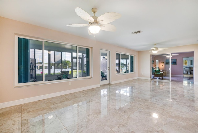 14544 Riverside Dr, Fort Myers, FL 33905 - empty room featuring marble tiled floors, ceiling fan, and baseboards