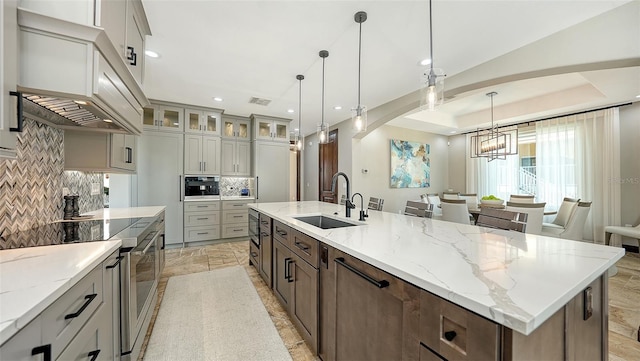 795 Marbury Ln, Longboat Key, FL 34228 - kitchen with a chandelier, decorative backsplash, a large island, recessed lighting, and glass insert cabinets