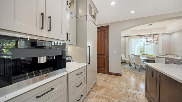 795 Marbury Ln, Longboat Key, FL 34228 - kitchen featuring stone tile flooring, a chandelier, recessed lighting, decorative light fixtures, and glass insert cabinets