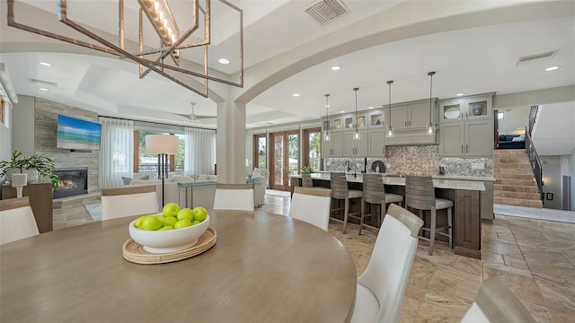795 Marbury Ln, Longboat Key, FL 34228 - dining space featuring a large fireplace, recessed lighting, arched walkways, and stone tile flooring