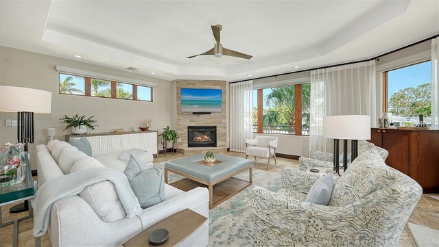 795 Marbury Ln, Longboat Key, FL 34228 - living area featuring a raised ceiling, a glass covered fireplace, a ceiling fan, and recessed lighting