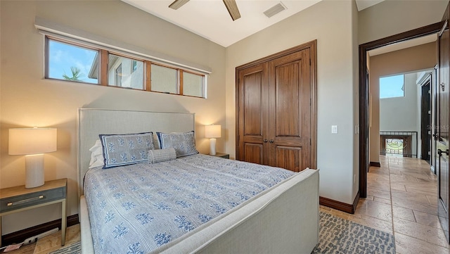 795 Marbury Ln, Longboat Key, FL 34228 - bedroom featuring a closet, stone tile floors, and a ceiling fan
