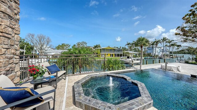 795 Marbury Ln, Longboat Key, FL 34228 - view of swimming pool featuring a pool with connected hot tub, a water view, and a patio area