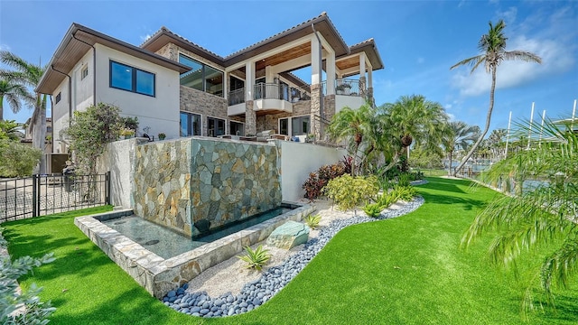 795 Marbury Ln, Longboat Key, FL 34228 - rear view of property with stucco siding, stone siding, and a tiled roof