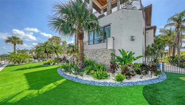 795 Marbury Ln, Longboat Key, FL 34228 - view of side of property featuring a balcony, stucco siding, and stone siding